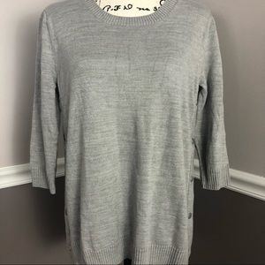 Gray knit sweater with 3/4 length sleeves and button snap sides